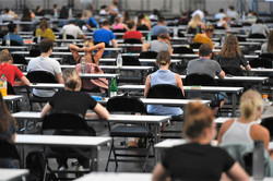 Viele Studierende sitzen mit Abstand zueinander an Tischen.