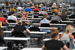 Klausur in den Westfalenhallen Viele Studierende sitzen mit Abstand zueinander an Tischen.