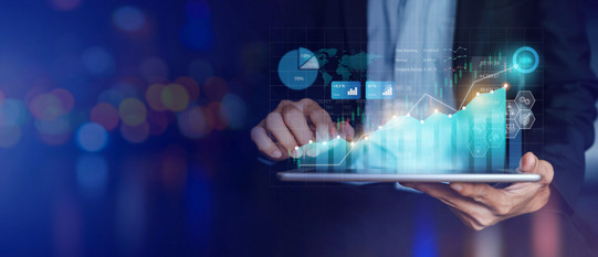 Hands holding a tablet, above them are diagrams and graphs