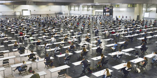 Klausuren Westfalenhalle Studierende sitzen an Tischen in der Westfalenhalle.