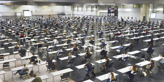 Klausuren Westfalenhalle Studierende sitzen an Tischen in der Westfalenhalle.