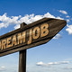 Das Bild zeigt ein pfeilförmiges Schild, auf dem Dream Job steht.