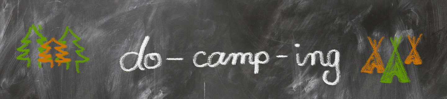 Schriftzug do-camp-ing mit weißer Kreide auf einer Tafel geschrieben.