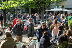 Teilnehmende und Zuschauende verweilen auf dem Campus