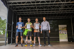 die drei schnellsten Läufer stehen auf der Bühne, daneben Christoph Edeler, Leiter des Hochschulsports