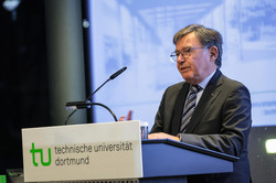 Ein Mann hält an einer Kanzel mit TU-Logo eine Rede 