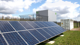 November Photovoltaikanlage auf grünem Rasen mit Wolken am Himmel.