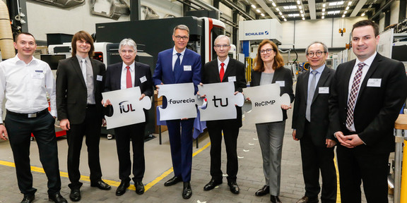 ReCIMP Gruppenfoto in Werkhalle, vier Personen halten Puzzleteile mit Logos der beteiligten Institute in Händen