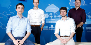 Vier Männer vor einem blauen Hintergrund
