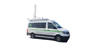 Ein Lieferwagen, der mit einer Antenne auf dem Dach ausgestattet ist und auf dem das Logo der TU Dortmund zu sehen ist.