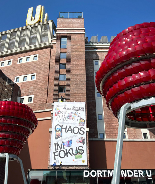 Das Dortmunder U mit einem Banner mit der Aufschrift "Chaos im Fokus"