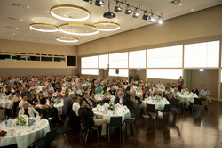 A banquet hall where many people sit at tables.