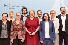 Juli Eine Gruppe von Menschen vor einem Banner des Bundesministeriums für Familie, Senioren, Frauen und Jugend