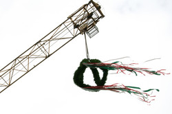 Topping-out wreath hangs from construction crane