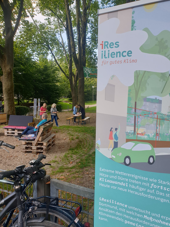 Der Blücherpark in der Dortmunder Nordstadt und rechts ein Roll-up Poster des Projekts iResilience.