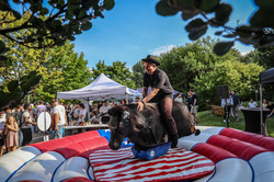 Foto: Ein Mann mit einem Cowboyhut reitet auf einem mechanischen Bullen.