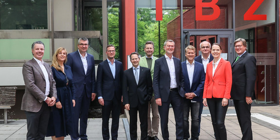 Gesellschaft der Freunde der TU Dortmund Mehrere Personen stehen in einer Reihe draußen vor einem Gebäude.
