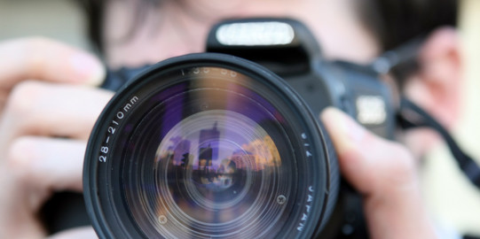 Close up of man looking through camera lens