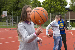 Eine Frau dreht einen Basketball auf ihrem Zeigefinger.