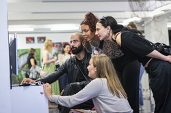 Foto: Vier Personen schauen sich gespannt eine digitale Kunstinszenierung an.