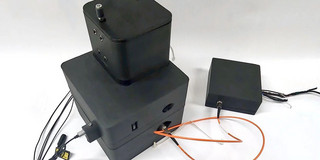 Schwarzes technisches Gerät mit Kabelanschlüssen und Zubehör.
