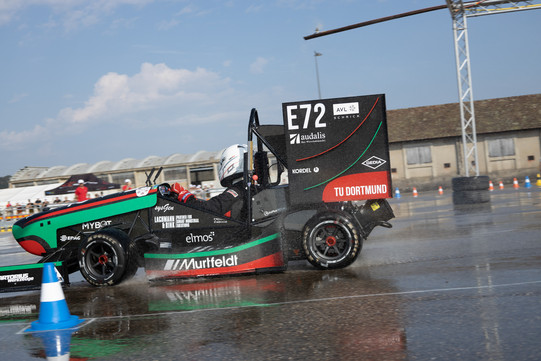 GET racing bei Formula Student France Ein kleiner Rennwagen fährt an einem sonnigen Tag über eine nasse Teststrecke