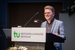 Foto: Dominik Speck, Gewinner des Lehrpreises in der Kategorie Lehrveranstaltungen mit weniger als 60 Teilnehmenden, vom Institut für Journalistik steht bei der Akademischen Jahresfeier der TU Dortmund am Redepult.