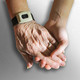 Die Hand eines alten Menschen wird von der Hand eines jungen Menschen gehalten. 