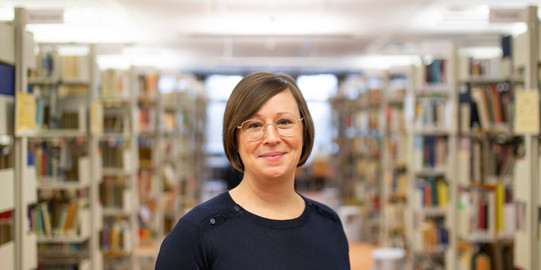 Portrait Nina Hogrebe Portrait einer Frau in einer Bibliothek