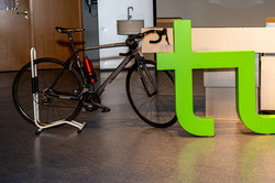 Ein E-Bike steht neben dem Logo der TU Dortmund in einem Hörsaal.