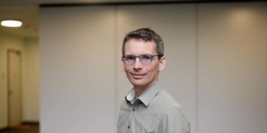 Prof. Kevin Buchin Ein Porträtbild von einem Mann, Prof. Kevin Buchin vor einer weißen Wand.