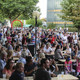 Viele Menschen sitzen auf dem Campus.