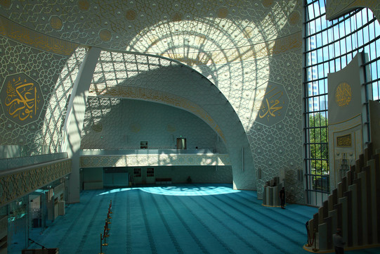 Zentralmoschee Köln Der Innenraum einer Moschee, rechts die Tür zwischen wandhohen Fenstern