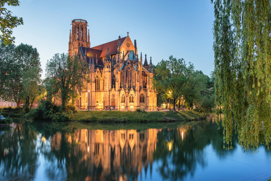 Kirche am See Eine beleuchtete christliche Kirche bei Dämmerung an einem See.
