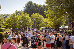 Besucher*innen eines Sommerfests sind auf einem Uni-Campus.