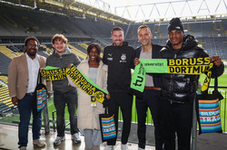 Die Gewinner*innen des Gewinnspiels bei der Erstsemesterbegrüßung halten TU Dortmund/BVB-Schals. Neben ihnen stehen Christoph Edeler, Kevin Großkreutz und Johannes Zedel.