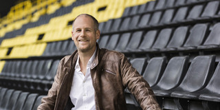 Juniorprofessor Andreas Groll sitzt auf der Tribüne eines Fußballstadions