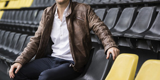 Juniorprofessor Andreas Groll sitzt auf der Tribüne eines Fußballstadions