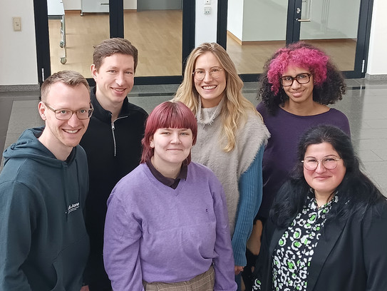 Die Schreibgruppe lächelt in die Kamera