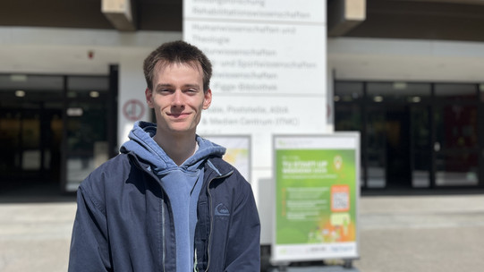 Der Student Tommy Köhler steht vor dem Gebäude EF50.