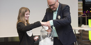Joachim Hecker und eine Teilnehmerin begutachten den weißen Superabsorber in einer Tüte.