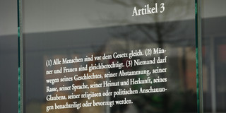 Der Artikel 3 des Grundgesetzes zur Gleichheit von Männern und Frauen steht auf einer Platte aus Glas, aufgenommen am 03.04.2016 in  Berlin im Bezirk Mitte im Regierungsviertel. Nach Artikel 3 darf auch Niemand wegen seiner Rasse, Herkunft oder politischen Anschauungen diskriminiert werden.