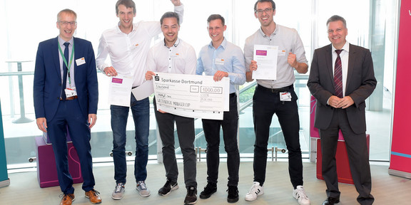 Westenergie Manager Cup Mehrere Personen stehen in einer Reihe und halten einen großen Scheck in der Hand.