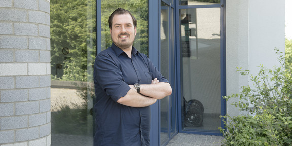 Alexander Michalik Alexander Michalik steht vor einem Gebäude auf dem TU-Campus.