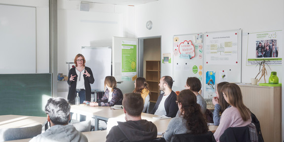 Schreibwerkstatt Dozentin spricht im Seminarraum vor Studierenden