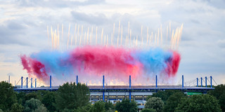 Foto: Die Schauinsland-Reisen-Arena in Duisburg bei der Eröffnungszeremonie mit buntem Feuerwerk aus der Ferne.