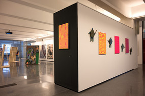 Das Foto zeigt einen Teil eines Ausstellungsraums an dessen Wänden Kunstwerke hängen.