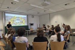 Veranstaltung "Spielerisch zur assistiven Robotik" Teilnehmende schauen auf eine Präsentation über Roboter.
