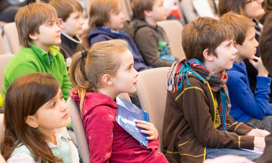 Grundschüler im Hörsaal Grundschüler sitzen in einem Hörsaal