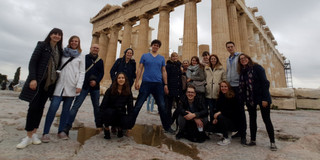 A group of students in front of an ancient building in Greece.